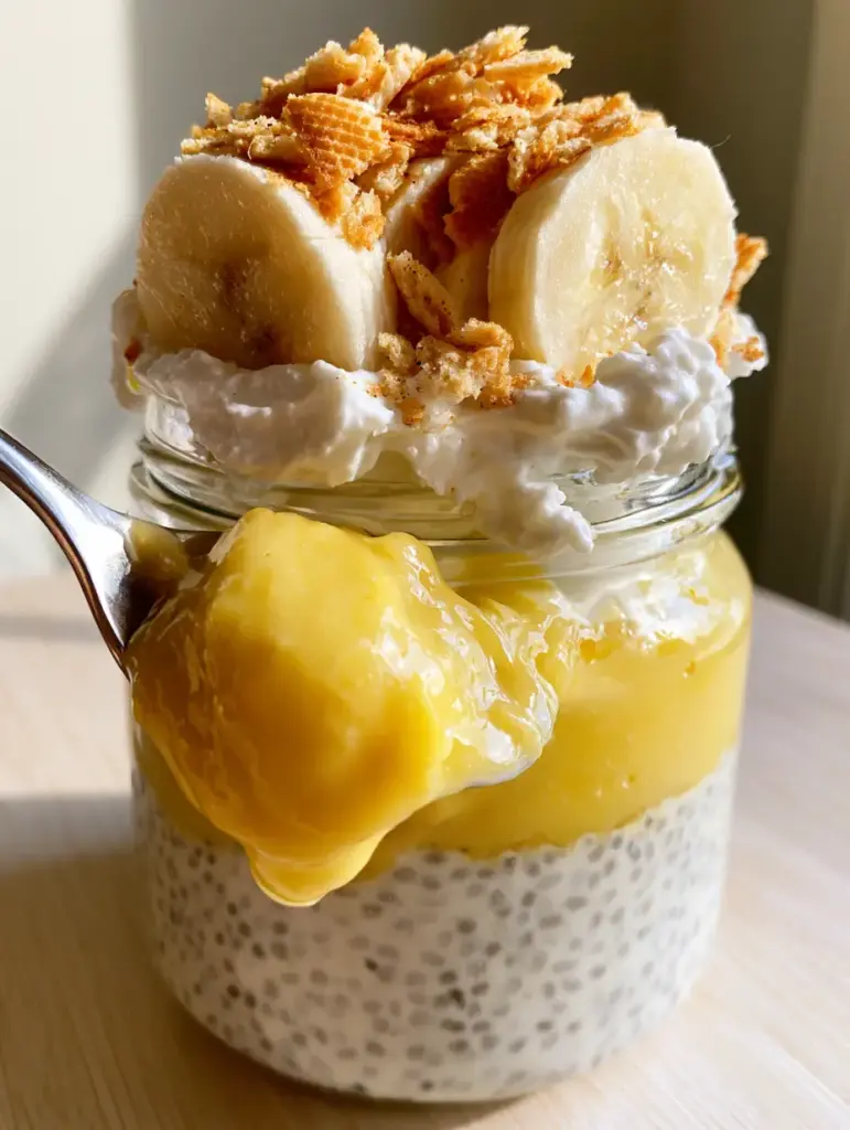 Banana Cream Pie Chia Pudding: The Ultimate Creamy, Layered Breakfast 2 Close up of a silver spoon scooping a thick glob of Banana Cream Pie Chia Pudding with vanilla bean seeds visible.