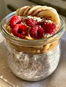 Close up of thick overnight oats with water showing hydrated chia seeds and distinct rolled oat grains.