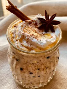Close up of vanilla chai overnight oats showing thick texture and vanilla bean flecks in a glass jar.