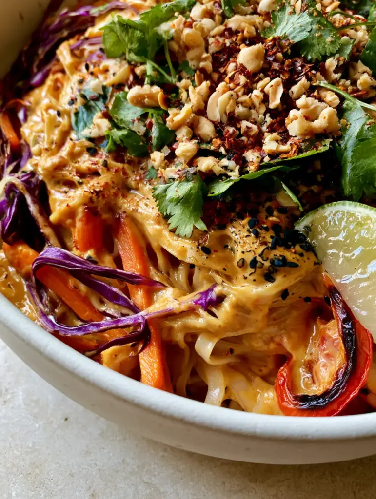 Vibrant purple cabbage and fresh cilantro garnish on a Thai noodle casserole.