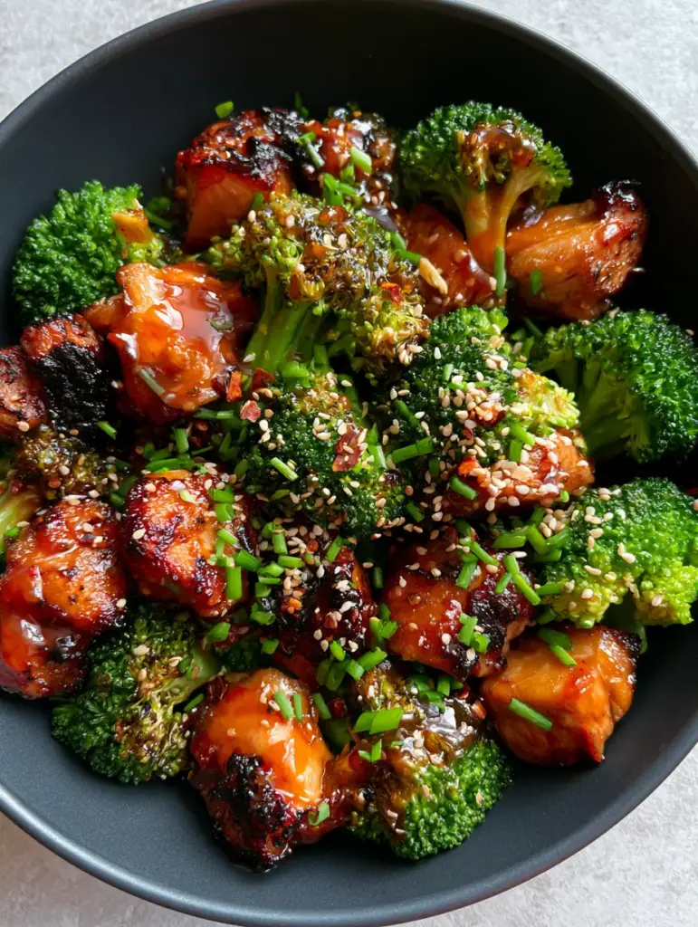 Honey Sriracha Chicken and Broccoli: The Ultimate 30-Minute Sticky Stir Fry 2 Close-up of caramelized Honey Sriracha Chicken chunks with charred edges and a thick translucent red glaze. (Honey Sriracha Chicken and Broccoli)
