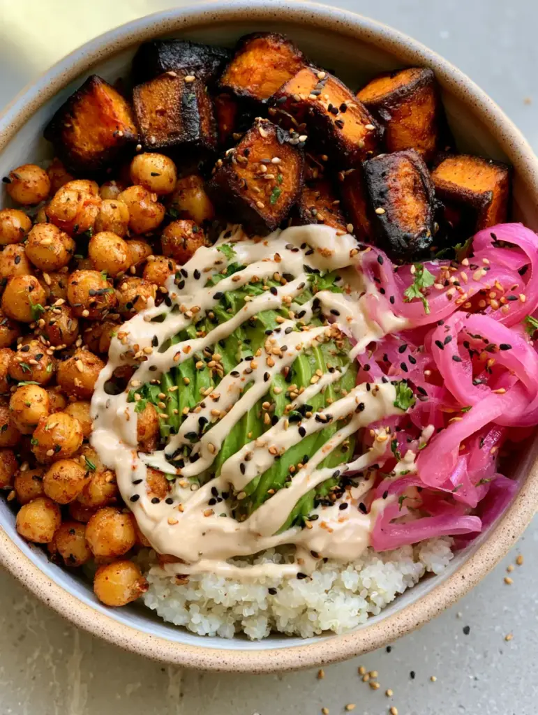 Angled smartphone photo of a Sweet Potato Chickpea Buddha Bowl with visible steam and toasted black sesame seed garnish.